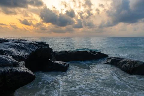 Sunrise dramatic sky over sea horizon from rocky shore at dawn from flat angl Foto stock