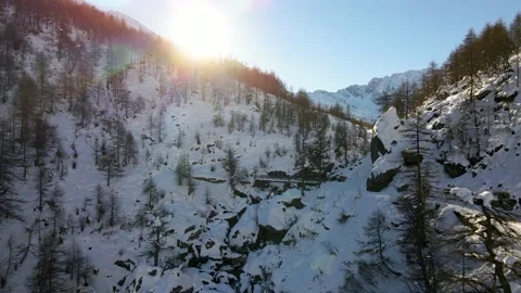 Sunrise drone flight toward the sun in the mountain with snow, tree, stream. 4k Stock Footage 148031267