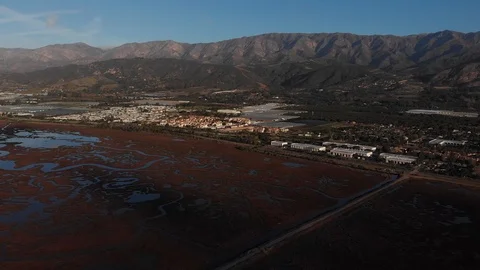 Sunrise Drone Over Marsh With Mountains and Distant Traffic 库存影片 100655977