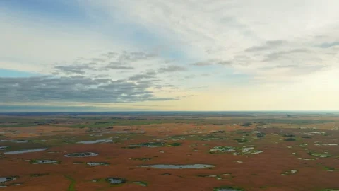 Sunrise Drone Shot Over Patchwork Crops and Prairie Wetlands in Saskatchewan Stock Footage 347876386