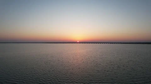 Sunrise drone view of long bridge crossing open water in China Stock Footage 337765432
