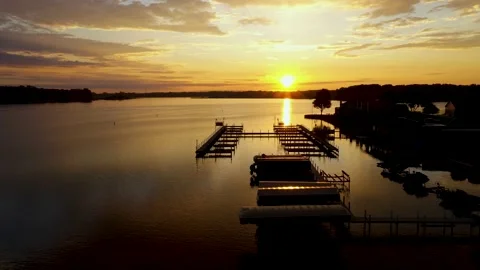 Sunrise Fox lake Low Aerial zoom in docks and sun over lake- Stock Footage