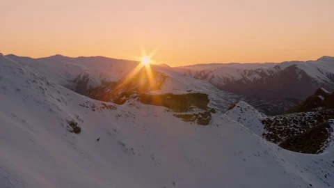 Sunrise in frame over snow clad peaks Stock Footage 159700642