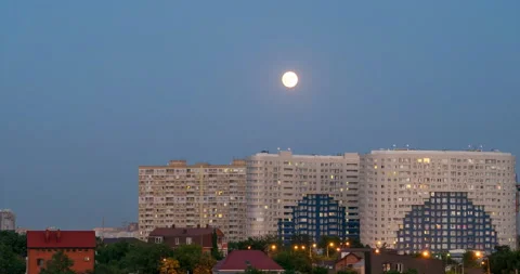 The sunrise of a full moon against the background of the urban landscape Stock Footage 94759989