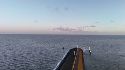 Sunrise glide above outer harbor defense and open water Stock Footage 331841306