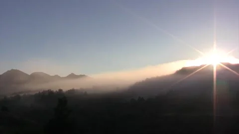 Sunrise hilly landscape with fog, pan to sunburst, 2nd cut over hills &amp; fog Stock Footage 269372753