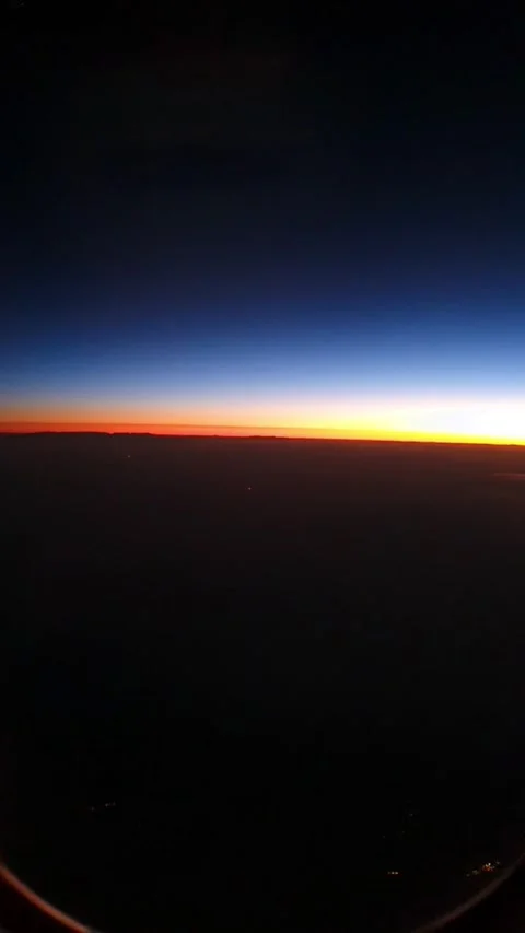 Sunrise horizon viewed from airplane window during flight. Colorful sky above cl Stock Footage 330174835