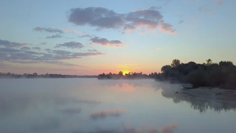 Sunrise on a lake through fog Stock Footage