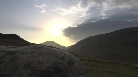 Sunrise lights a rugged mountain valley - Dramatic Clouds and Empty Landscape Stock Footage 339791690