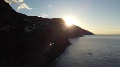 Sunrise in Madeira; the sun bursts forth from behind a headland Stock Footage 300341498