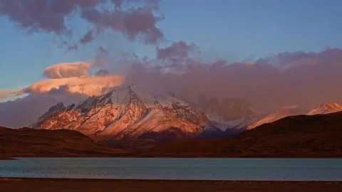 Sunrise magic with orange lenticular clouds moving over mountains in Patagonia Stock Footage 340404564