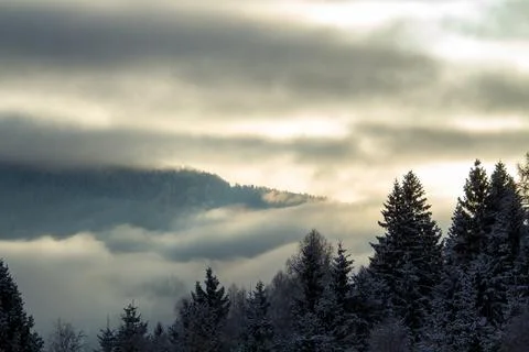 Sunrise makes a breakthrough in the mist between the mountains Stock Photos