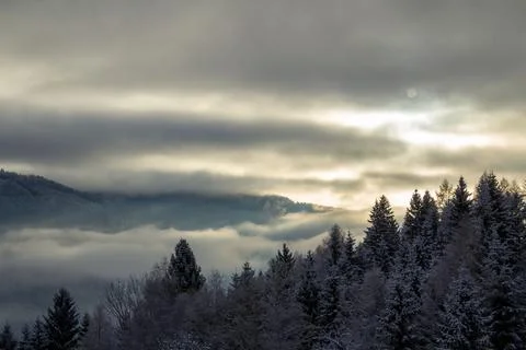Sunrise makes a breakthrough in the mist between the mountains Stock Photos