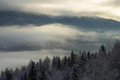 Sunrise makes a breakthrough in the mist between the mountains Stock Photos