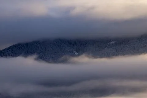 Sunrise makes a breakthrough in the mist between the mountains Stock Photos