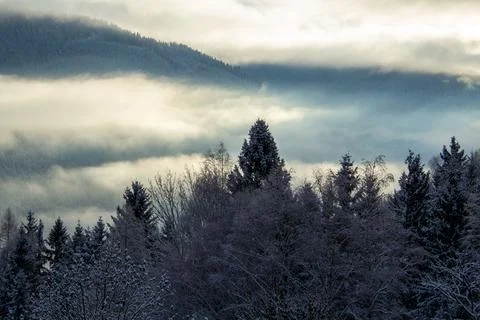 Sunrise makes a breakthrough in the mist between the mountains Stock Photos