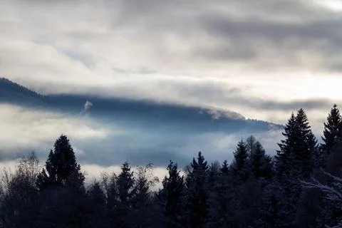 Sunrise makes a breakthrough in the mist between the mountains Stock Photos