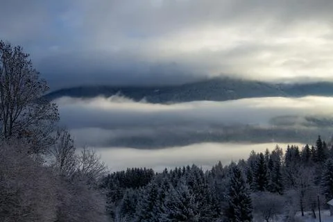 Sunrise makes a breakthrough in the mist between the mountains Stock-Fotos