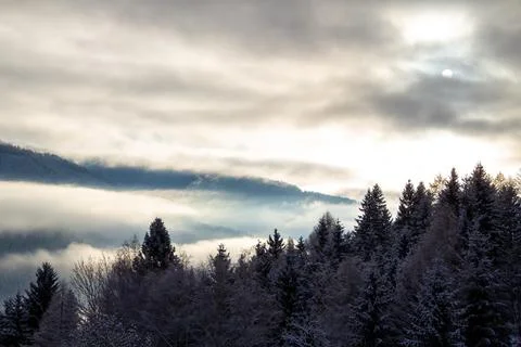 Sunrise makes a breakthrough in the mist between the mountains Stock Photos