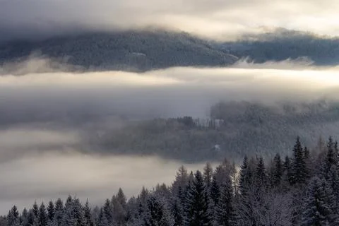 Sunrise makes a breakthrough in the mist between the mountains Foto stock