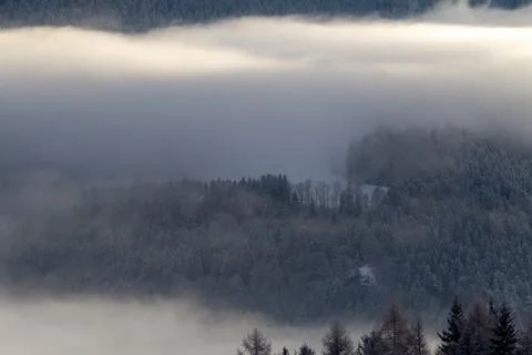 Sunrise makes a breakthrough in the mist between the mountains Stock Photos