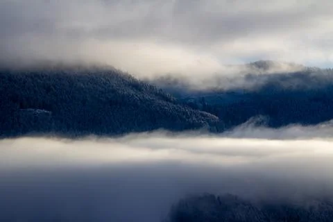 Sunrise makes a breakthrough in the mist between the mountains Stock Photos