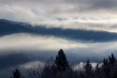 Sunrise makes a breakthrough in the mist between the mountains Stock Photos