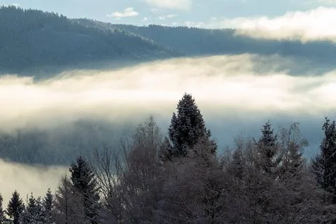 Sunrise makes a breakthrough in the mist between the mountains Stock Photos