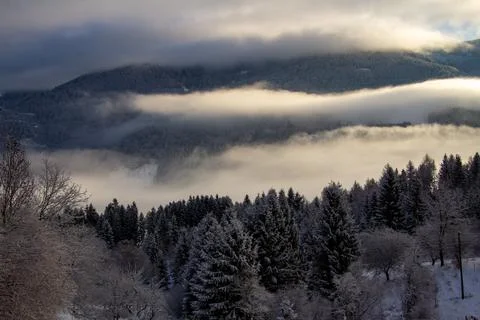 Sunrise makes a breakthrough in the mist between the mountains Foto stock