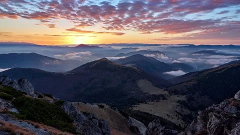 Sunrise in a mountain landscape. The clouds are painted in warm colors. Video stock 165268070