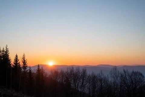 Sunrise in the mountains with trees in the foreground Stock Photos