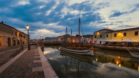 Sunrise with moving clouds over Cesenatico harbor with ancient sailboats Stock Footage 233489893