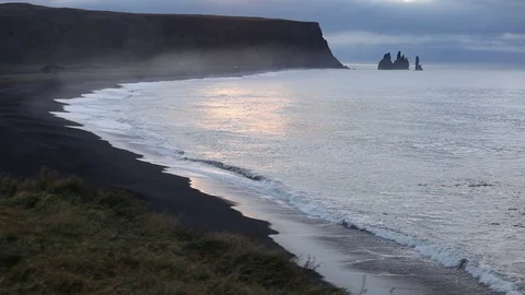 Sunrise on the ocean. Waves run on a black sandy beach. Stock Footage 95969776