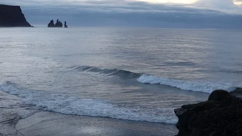 Sunrise on the ocean. Waves run on a black sandy beach. Stockbeeldmateriaal 95969862