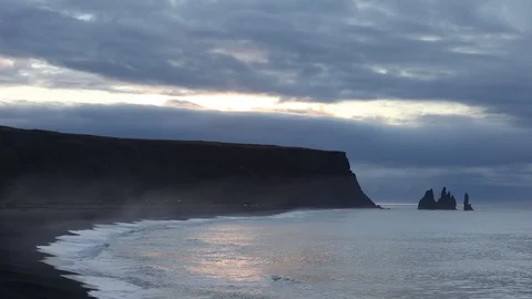 Sunrise on the ocean. Waves run on a black sandy beach. 库存影片 95969868
