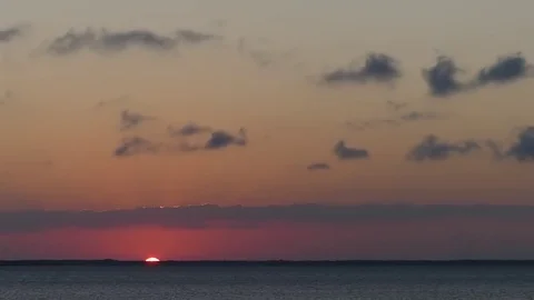 Sunrise, orange time lapse over St. Joe Bay, clouds fly by upper third Stock Footage 70006332