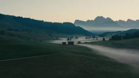 Sunrise over Alpine Mountain Valley with Mist Covering Green Meadow Grass 库存影片 331168918