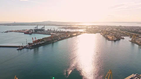 Sunrise over the busy harbor showcasing ships, cranes, and a city skyline in the Stock Footage 345458381