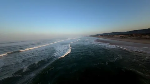 Sunrise over calm beach with waves gently breaking on shore 库存影片 346168553