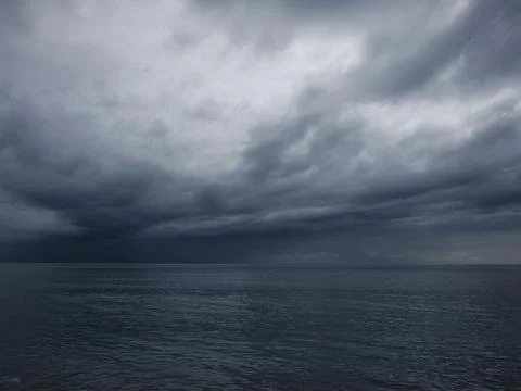 Sunrise over calm ocean with dramatic clouds Foto stock