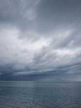 Sunrise over calm ocean with dramatic clouds Foto stock
