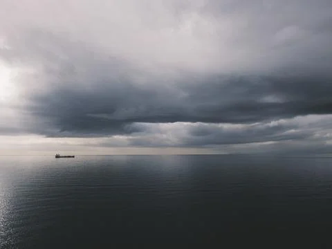 Sunrise over calm ocean with dramatic clouds Foto stock