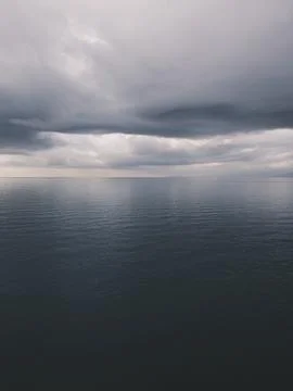 Sunrise over calm ocean with dramatic clouds Foto stock