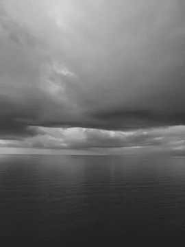 Sunrise over calm ocean with dramatic clouds Foto stock