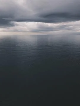 Sunrise over calm ocean with dramatic clouds Foto stock
