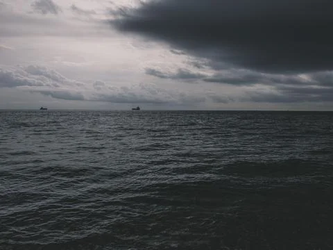 Sunrise over calm ocean with dramatic clouds Foto stock