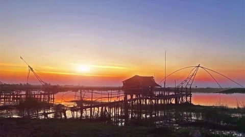 Sunrise over Coastal Industrial Structures and Fishing Nets Stock Footage 310243136