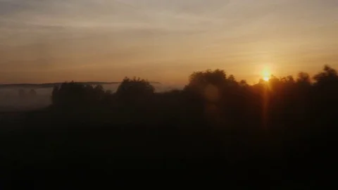 Sunrise over the countryside. View from the window of a moving train Stock Footage 76596375