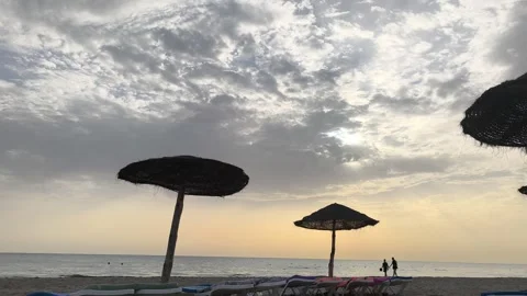 Sunrise Over Djerba Beach with Beach Umbrellas and people Video stock 342786366