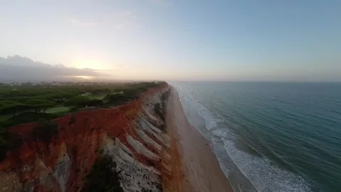 Sunrise over dramatic cliffside beach with rolling waves Vídeos de archivo 346089585